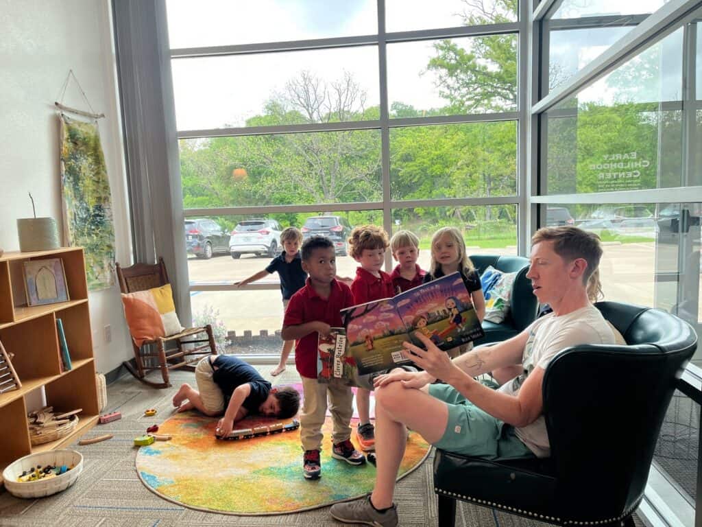 Selwyn School teacher reading aloud to a small group of children in a classroom on the Argyle campus