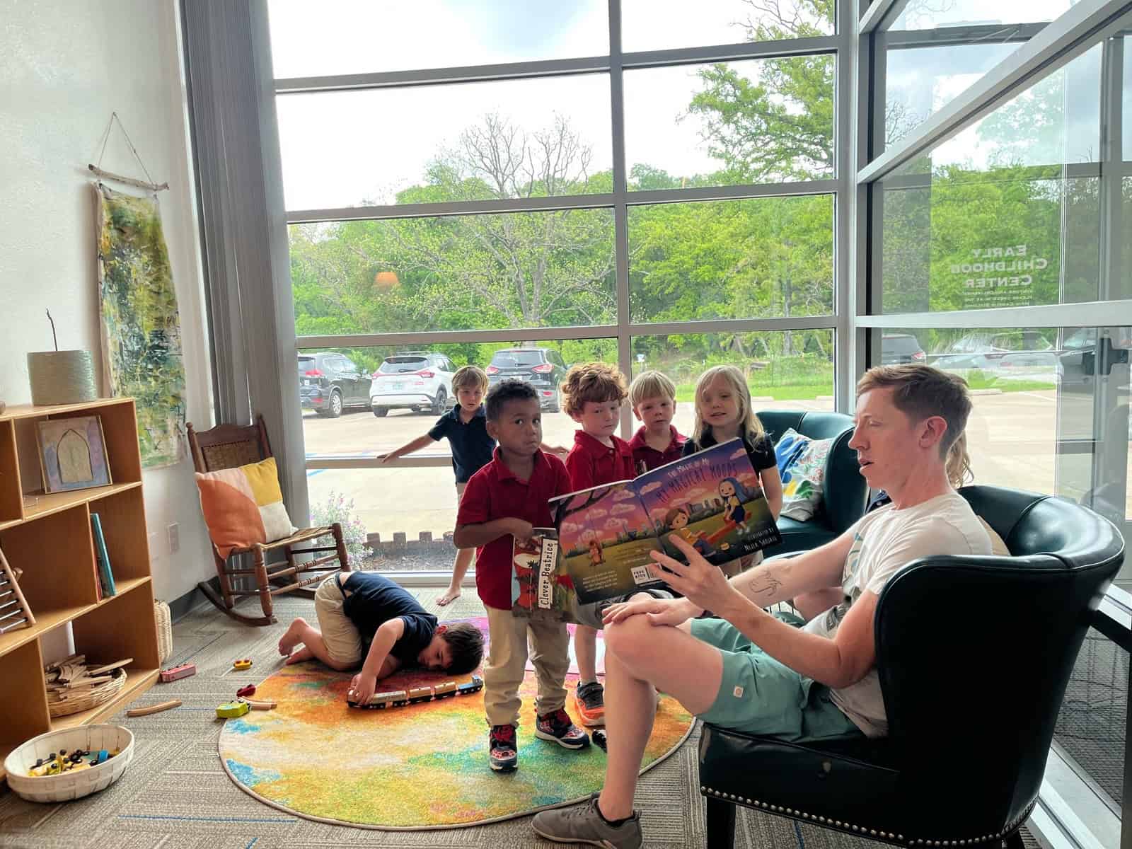 Selwyn School teacher reading aloud to a small group of children in a classroom on the Argyle campus